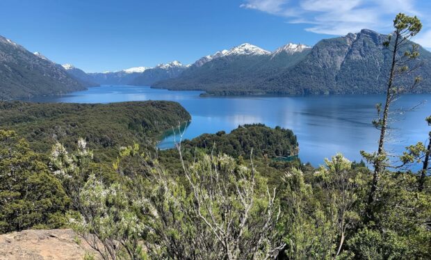 A clear view of Nahuel Huapi lake surrounded by green forests and snow capped mountains, HD Desktop Wallpaper