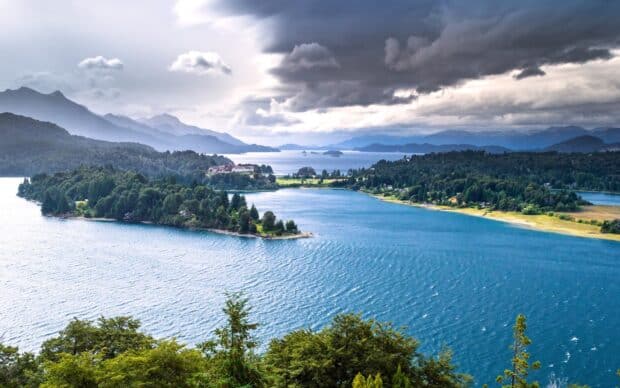 A stunning view of Nahuel Huapi lake surrounded by mountains and forest under cloudy sky, HD Desktop Wallpaper