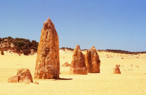 Tall limestone pillars standing in Nambung National Park desert under clear blue sky, HD Desktop Wallpaper