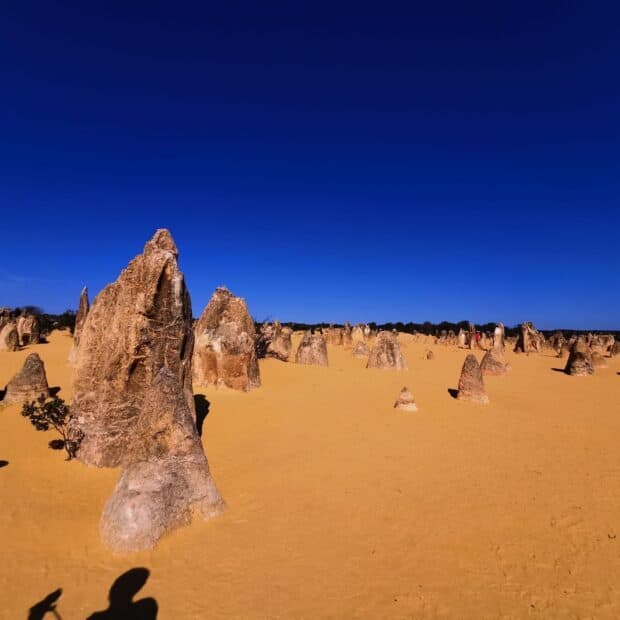Unique rock formations stand tall in Nambung National Park with a bright blue sky, HD Desktop Wallpaper