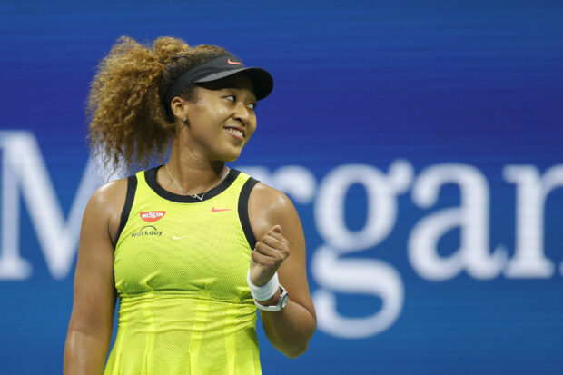 Naomi Osaka is smiling during a tennis match on a blue court, 2K Desktop Wallpaper
