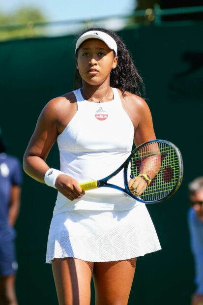 Naomi Osaka is focused while holding a tennis racket during a match, HD Desktop Wallpaper