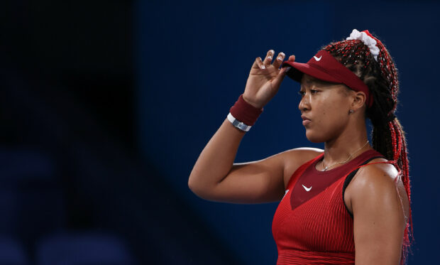 Naomi Osaka intensely prepares for a tennis match wearing a red outfit and visor, 2K Desktop Wallpaper