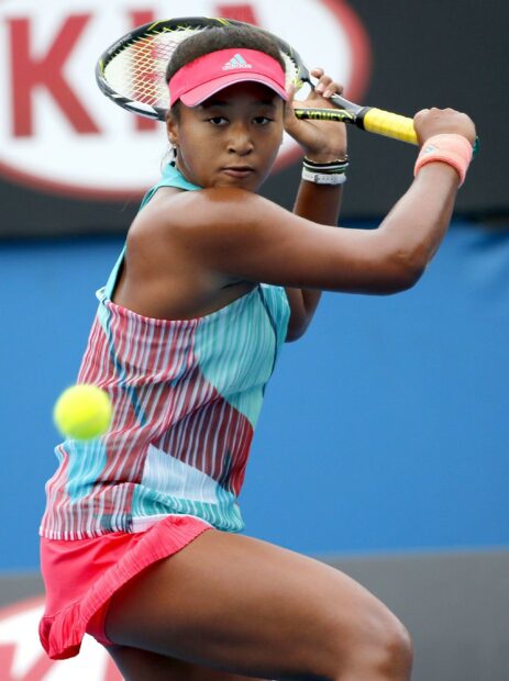 Naomi Osaka is focused during a tennis match preparing to hit the ball, 2K Mobile Wallpaper