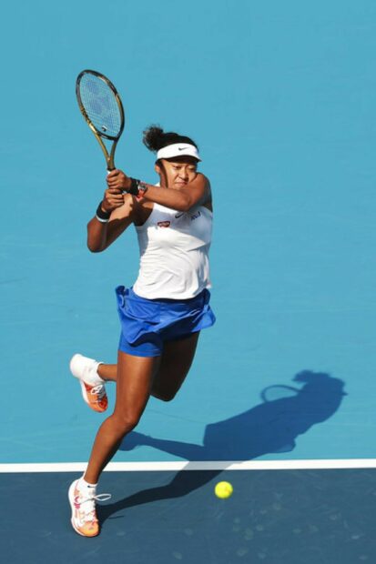 Naomi Osaka intensely hitting a backhand during a tennis match on a blue court, 2K Mobile Wallpaper