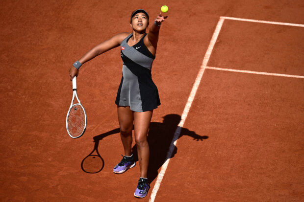 Naomi Osaka is focused while serving a tennis ball on a clay court during a match, HD Desktop Wallpaper