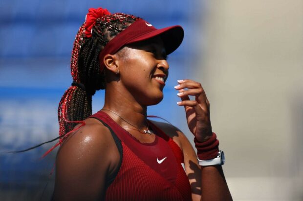 Naomi Osaka smiles warmly in a red outfit while playing tennis, HD Desktop Wallpaper