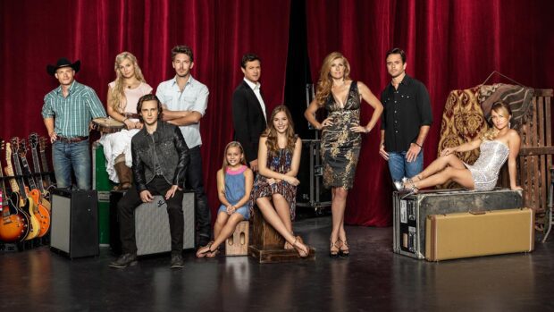The Nashville TV series cast poses together with musical instruments in front of a red curtain, HD Desktop Wallpaper