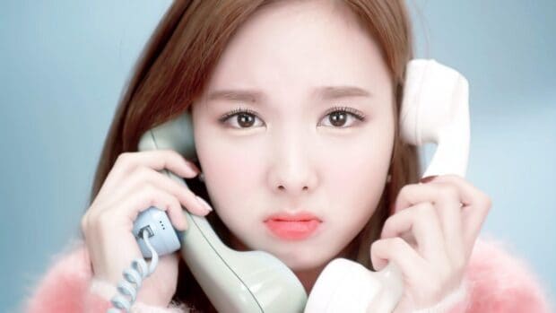 Nayeon holds two retro phones with a concerned expression on her face, HD Desktop Wallpaper