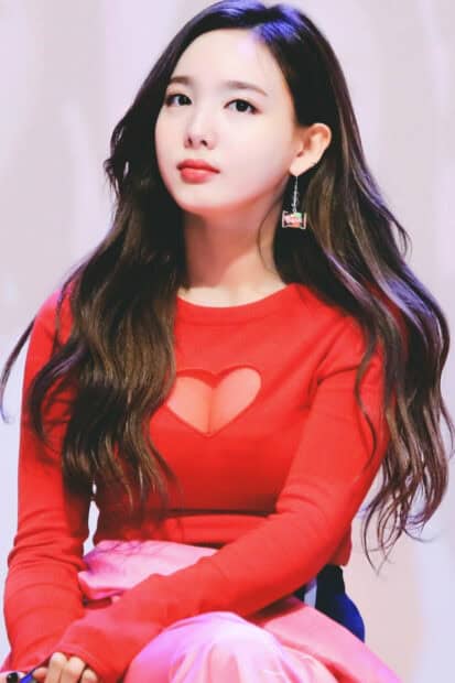 Nayeon Wallpapers shows a thoughtful expression while wearing a red sweater with a heart cutout, HD Mobile Wallpaper