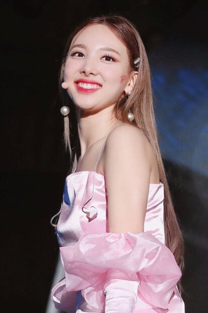 Nayeon Wallpapers showing a bright smile in a pink off shoulder dress during a performance, HD Phone Wallpaper