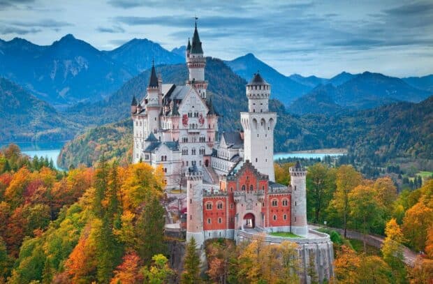 Neuschwanstein Castle surrounded by colorful fall trees under a cloudy sky, HD Desktop Wallpaper