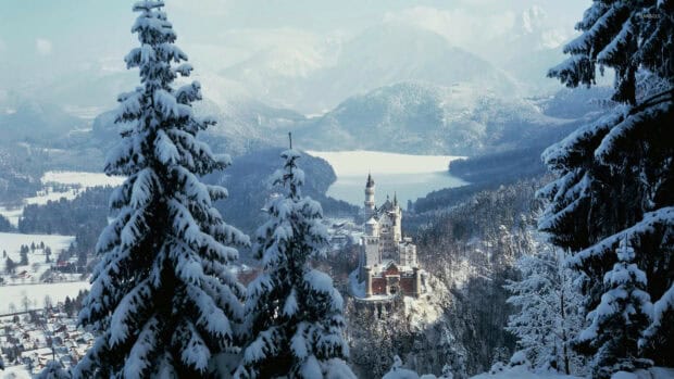 Neuschwanstein Castle surrounded by snow covered trees and mountains, HD Desktop Wallpaper