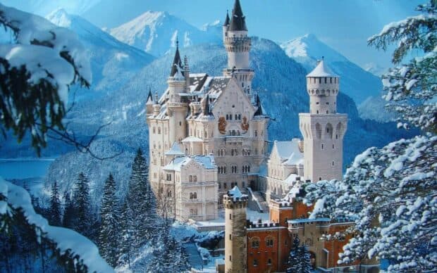The Neuschwanstein Castle stands surrounded by snowy trees and mountains, HD Desktop Wallpaper