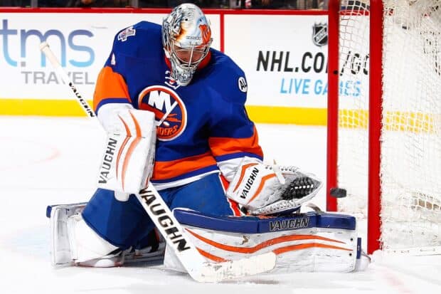A New York Islanders goalie is blocking a shot during a hockey game on ice, 2K Desktop Wallpaper