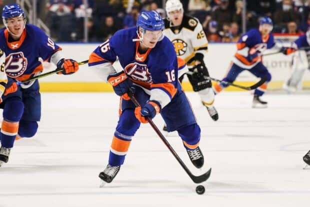 A New York Islanders player is controlling the puck during a hockey game on the ice rink, HD Desktop Wallpaper