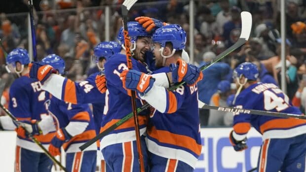 Two New York Islanders players embrace after scoring a goal in the game, HD Desktop Wallpaper