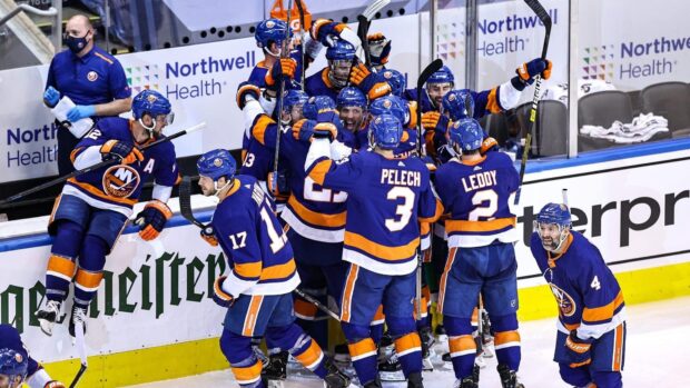 New York Islanders players in blue and orange uniforms celebrate on the ice after scoring, HD Desktop Wallpaper