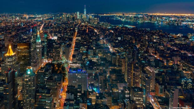 The image captures the vibrant New York skyline at night with illuminated buildings and streets, 4K Desktop Wallpaper