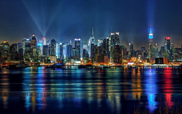 New York skyline at night with illuminated buildings reflecting on the water, HD Desktop Wallpaper
