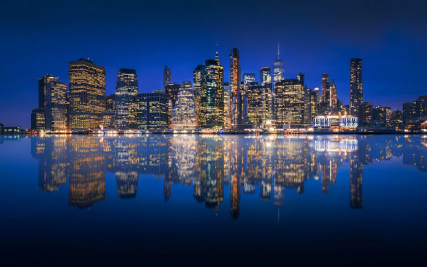 The New York skyline at night is beautifully reflected in the calm water, 2K Desktop Wallpaper