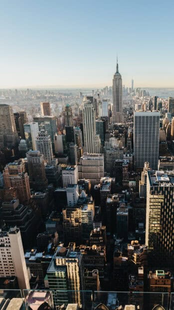 The New York skyline features iconic buildings lit by the early morning sun, 2K Phone Wallpaper