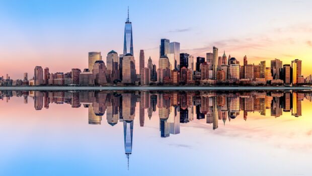 The New York skyline at sunset reflects beautifully on the calm water, 4K Desktop Wallpaper
