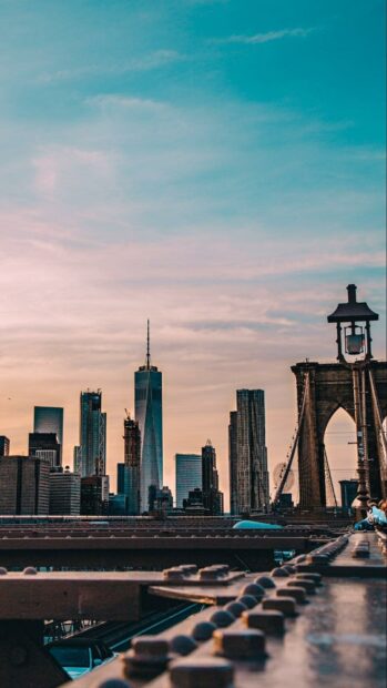 The New York skyline showcases tall buildings and a bridge during sunset, HD Mobile Wallpaper