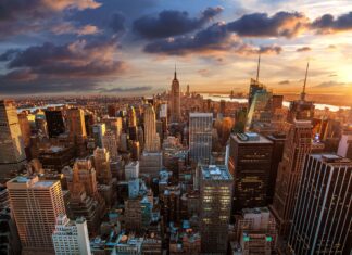 The New York skyline shows tall buildings lit by the sunset with a dramatic sky, 4K Desktop Wallpaper