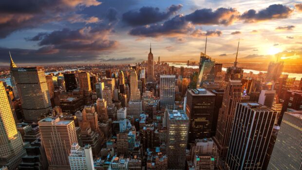 The New York skyline shows tall buildings lit by the sunset with a dramatic sky, 4K Desktop Wallpaper