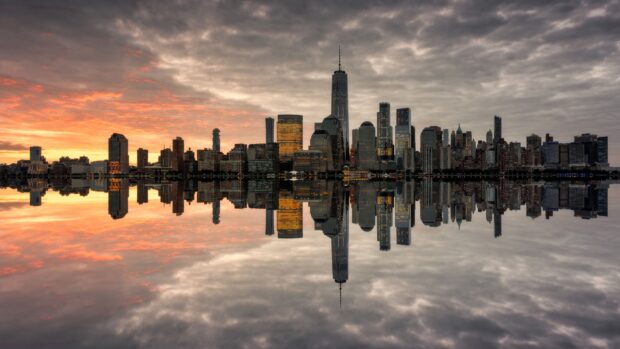 The New York skyline shows tall buildings and a sunset reflected in the water, 4K Desktop Wallpaper
