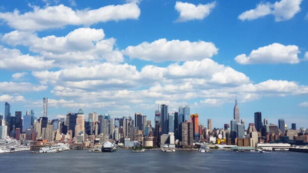 The New York skyline features tall buildings under a bright blue sky, 4K Desktop Wallpaper