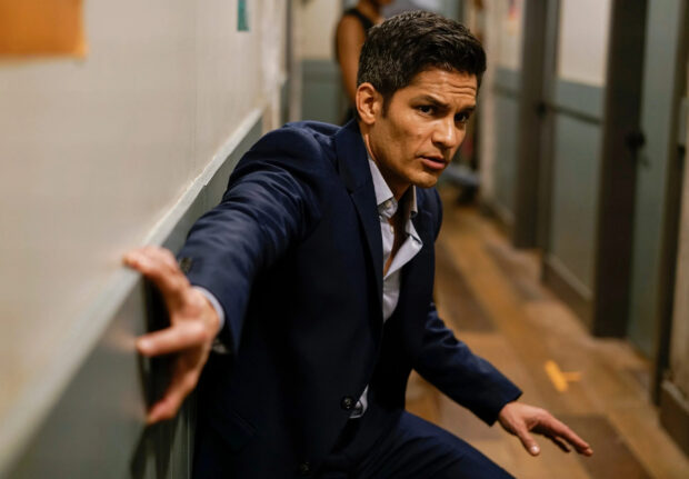 Nicholas Gonzalez shows a serious expression while leaning against a wall in a hallway, 2K Desktop Wallpaper