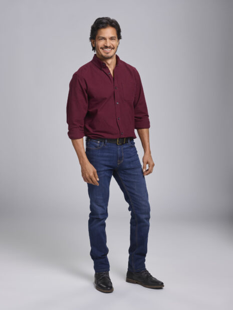 Nicholas Gonzalez smiles wearing a burgundy shirt and blue jeans in a studio, HD Desktop Wallpaper
