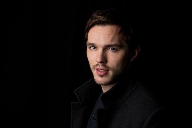 Nicholas Hoult wallpapers showing a man in a black coat with a dark background, 2K Desktop Wallpaper