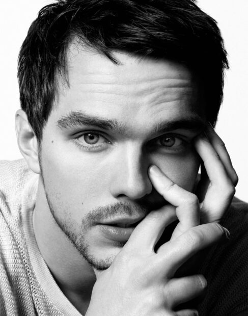 A thoughtful Nicholas Hoult looks into the camera with hand near face in black and white, HD Desktop Wallpaper