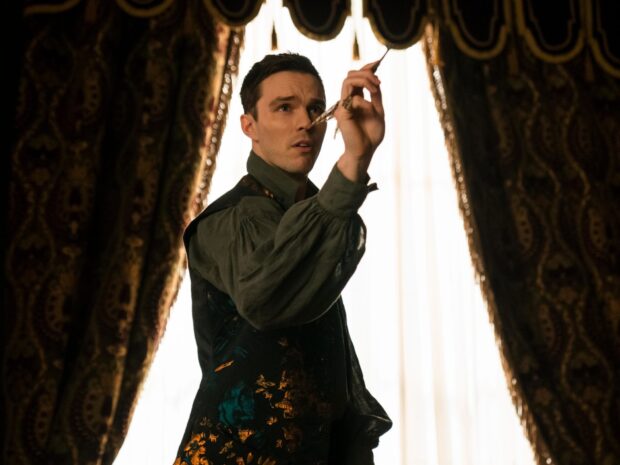 Nicholas Hoult is holding a dart and aiming indoors, HD Desktop Wallpaper