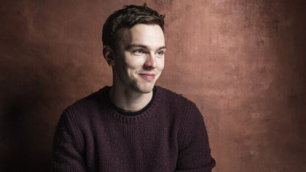 Nicholas Hoult wallpapers showing a man smiling and wearing a brown sweater against a textured background, HD Desktop Wallpaper