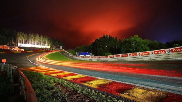 The race track features vivid light trails under a dramatic red sky at night, HD Desktop Wallpaper
