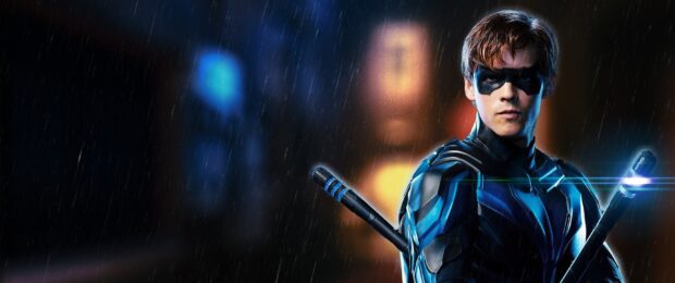 A man in a blue and black suit stands in the rain with weapons on his back from Titans Tv Series, 2K Desktop Wallpaper