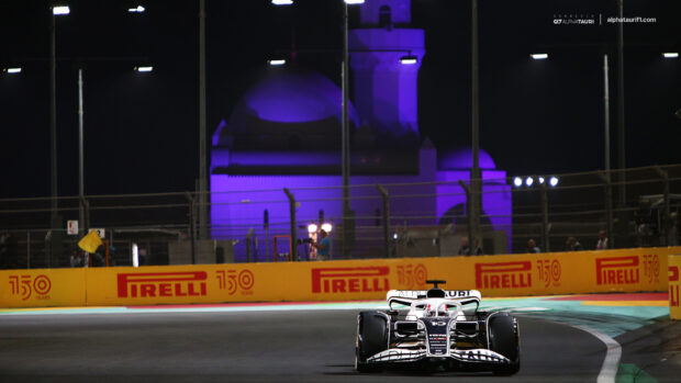 A Formula 1 car is driving on a race track at night with illuminated surroundings, HD Desktop Wallpaper