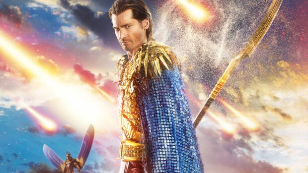 Nikolaj Coster Waldau stands confidently in golden armor with a blue cape and a spear, 4K Desktop Wallpaper