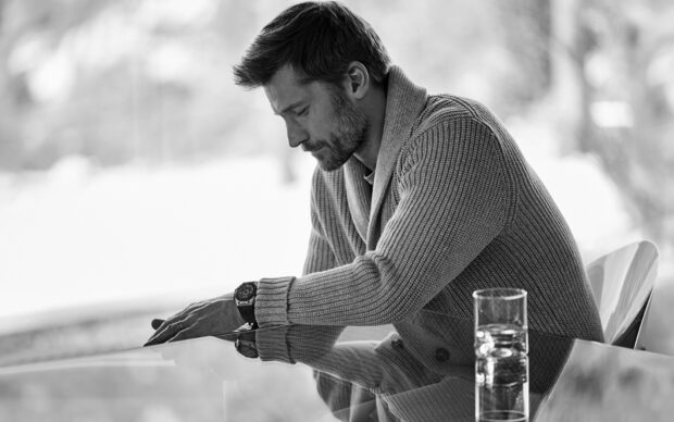 Nikolaj Coster Waldau is sitting pensively at a glass table wearing a knit sweater, HD Desktop Wallpaper