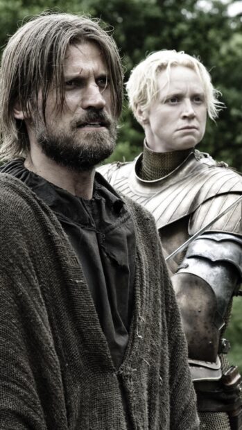 Nikolaj Coster Waldau stands serious beside a knight in armor in a forest setting, HD Phone Wallpaper