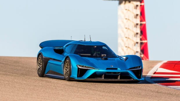A blue Nio auto is speeding on a race track near a red and white tower, 4K Desktop Wallpaper