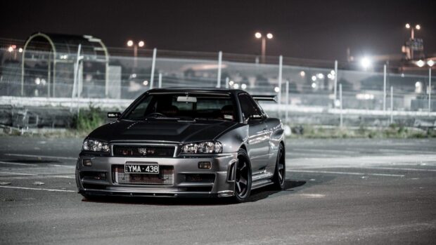 A Nissan GT R is parked under streetlights in an empty urban area at night, HD Desktop Wallpaper