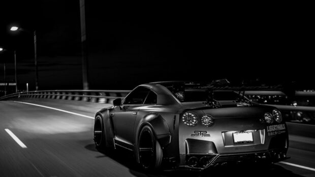A Nissan GT R is speeding along a curved urban road at night, HD Desktop Wallpaper