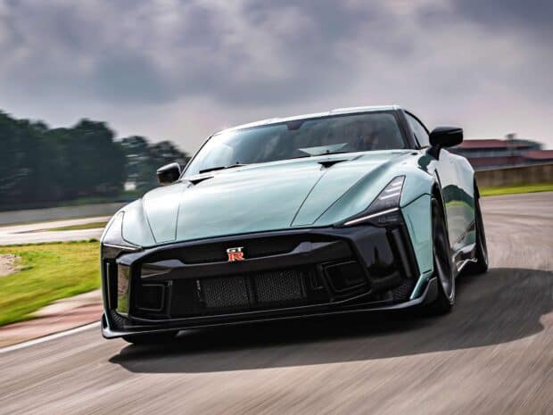 The Nissan GT R speeds along a curved race track under cloudy skies, HD Desktop Wallpaper