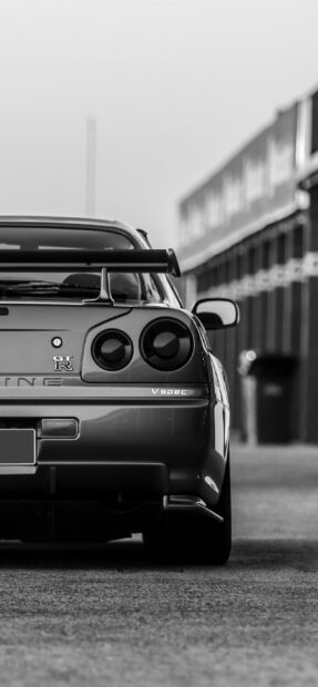 A Nissan GT R car is parked on the street with focus on the rear details, 2K Phone Wallpaper