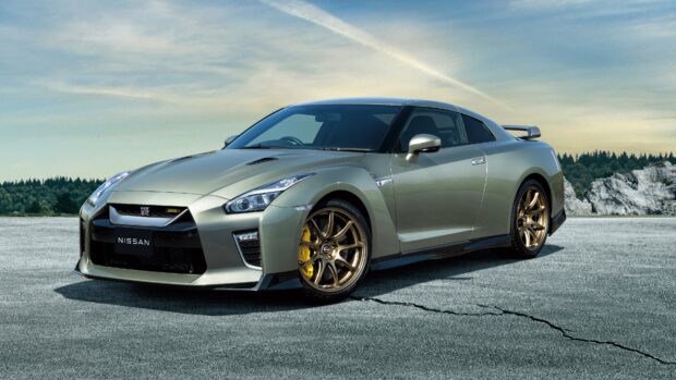 A Nissan GT R is parked on cracked pavement with trees and rocks in the background, 4K Desktop Wallpaper